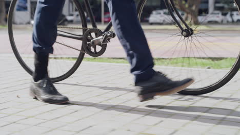 Business-man-walking-in-city-with-bike