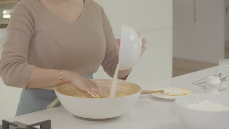 vista de una dama haciendo dulces agregando azúcar a la crema fresca y mezclando la mezcla a mano