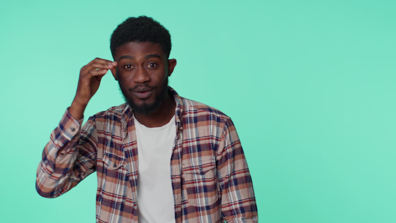 hombre sosteniendo la mano por encima de los ojos frente, mirando, mirando a su alrededor, esperando y buscando a alguien