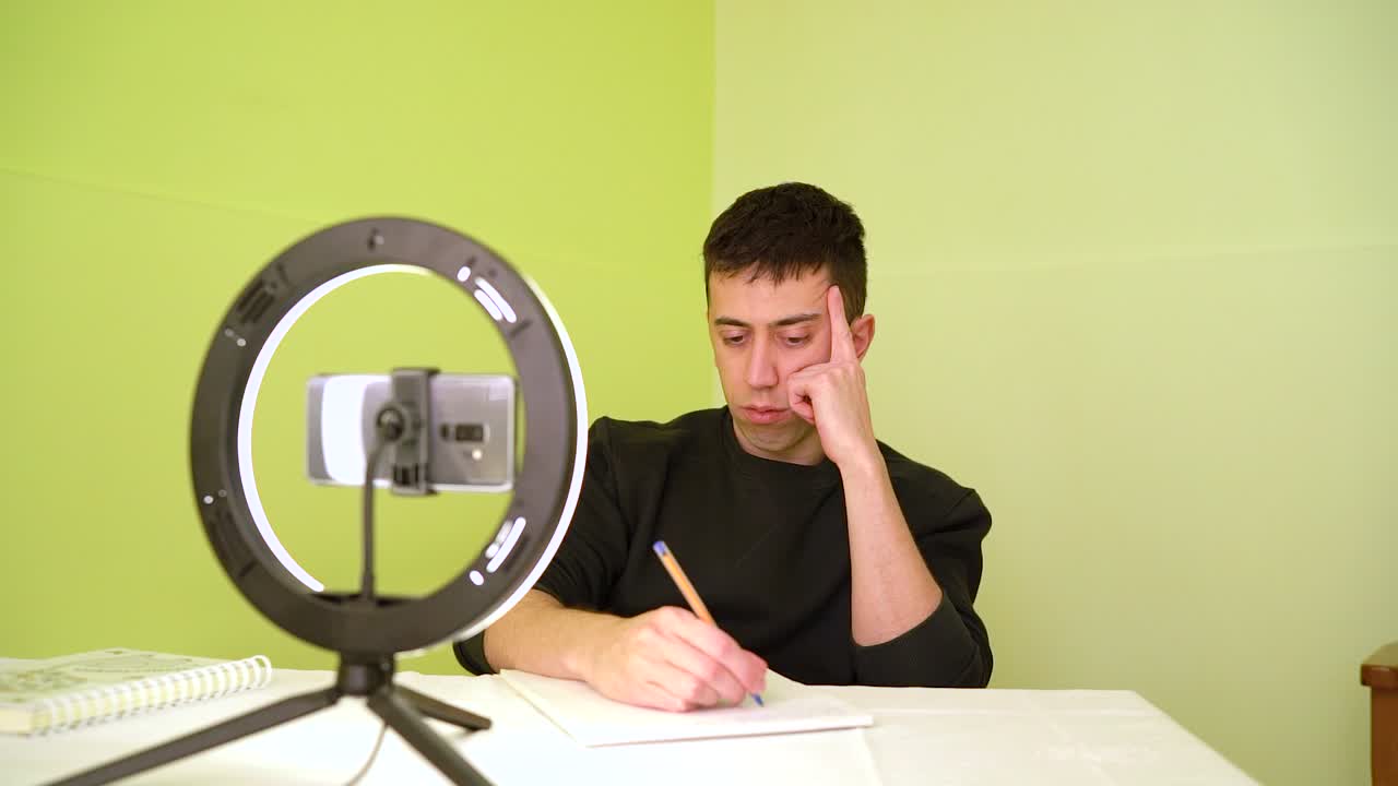 hombre tomando notas durante su clase en línea - medio