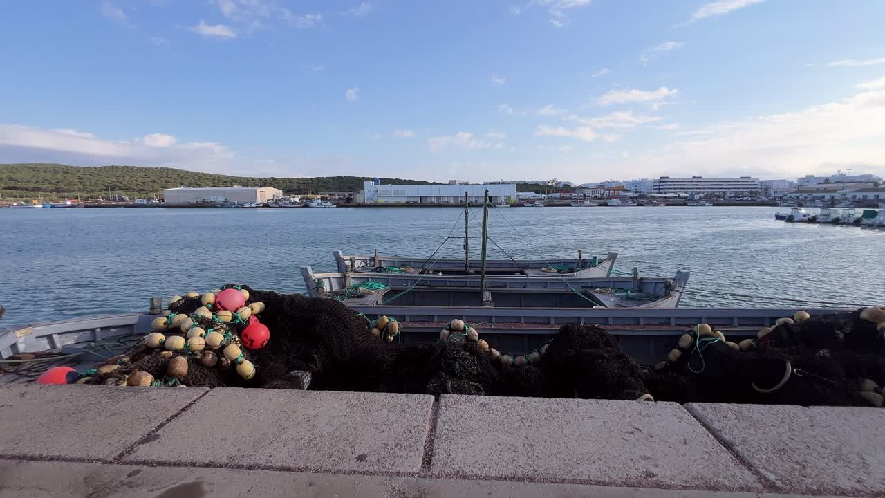 Fishing boats moored in the harbor under sunny weather with a clear sky.