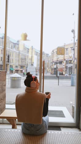 woman relaxing in a coffee shop with city view