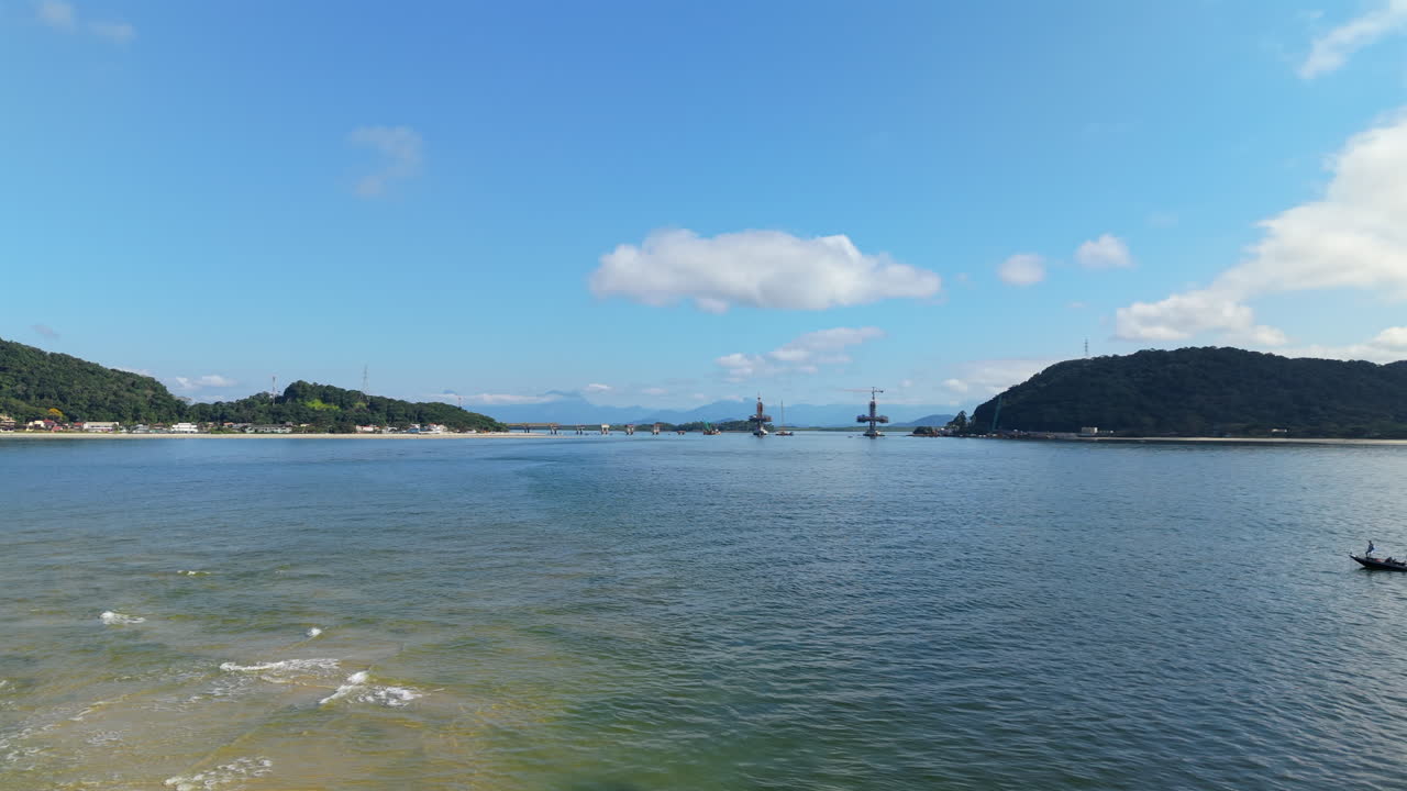 Far shot of Ponte de Guaratuba-Matinhos bridge construction over water, showing structure and surroundings