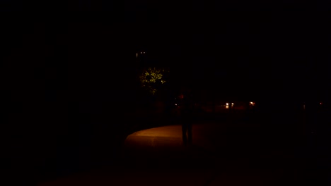 Man-walking-in-Boulder-Creek-Path-at-night-in-Boulder,-Colorado