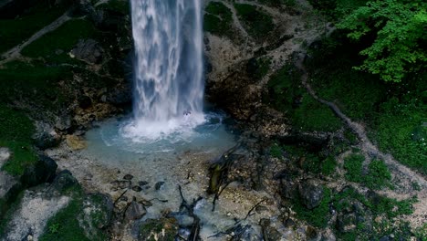 el hombre con barba está haciendo meditación de cascada bajo una gran cascada.