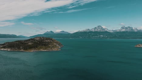 Rugged-Island-In-Beagle-Channel-Backdropped-By-Snowy-Mountains-In-Tierra-del-Fuego,-Patagonia,-Argentina