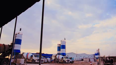 establishing cinematic push in shot construction site fully equipped with traktor, trucks, and concrete mixer trucks