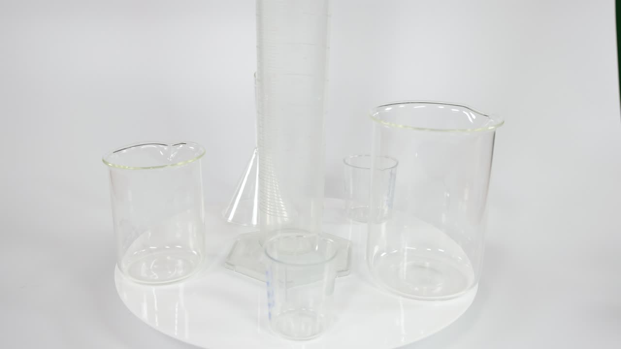 varios vasos y cilindros transparentes en una superficie blanca