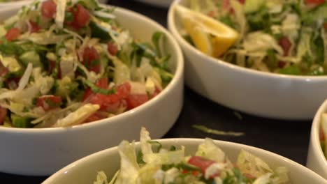 fresh vegetable salad served in bowls with lemon slices on the side, close up shot