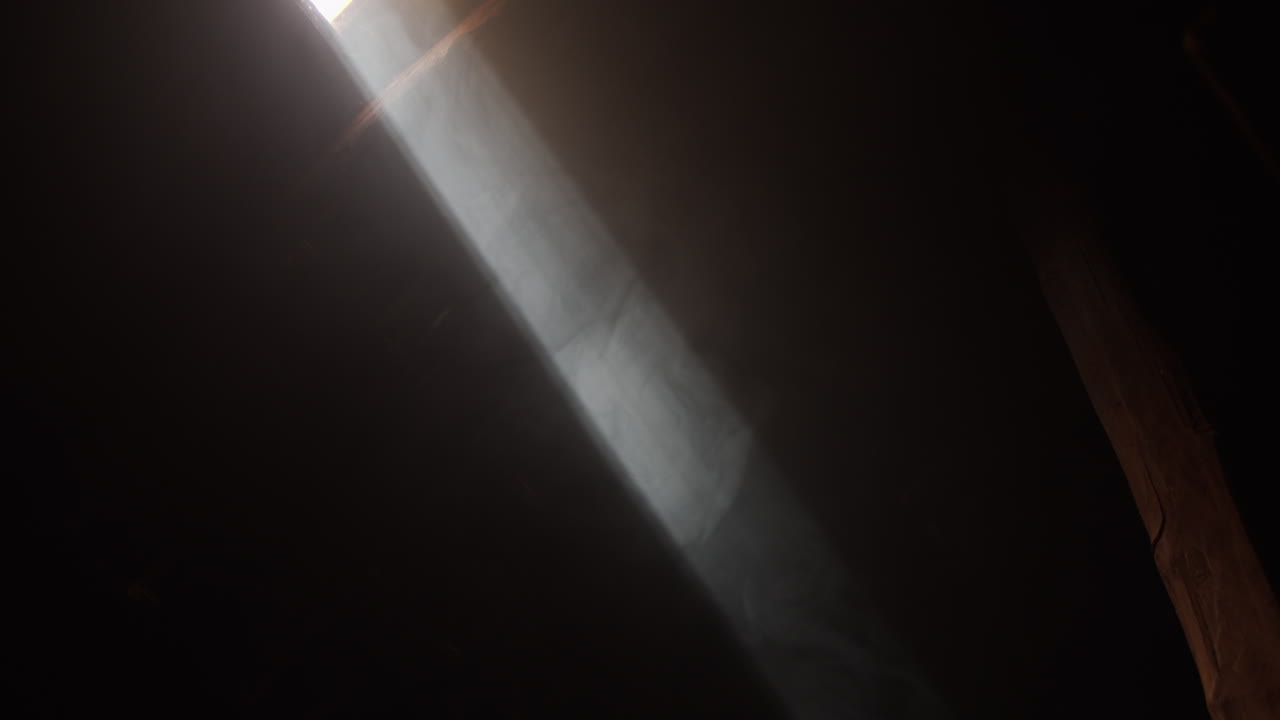 el rayo de sol ilumina la oscuridad a través del agujero en el techo de una casa antigua en un pueblo