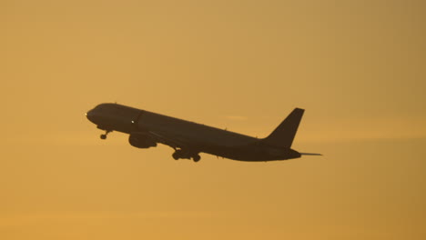 Plane-flying-in-evening-sky-against-sun-flare