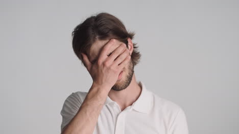 caucasian man in front of camera on gray background.