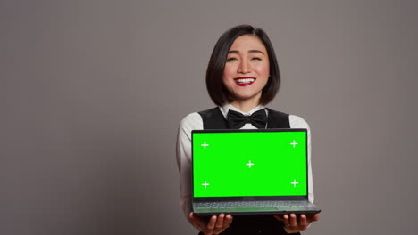 receptionist showing greenscreen display on personal laptop,