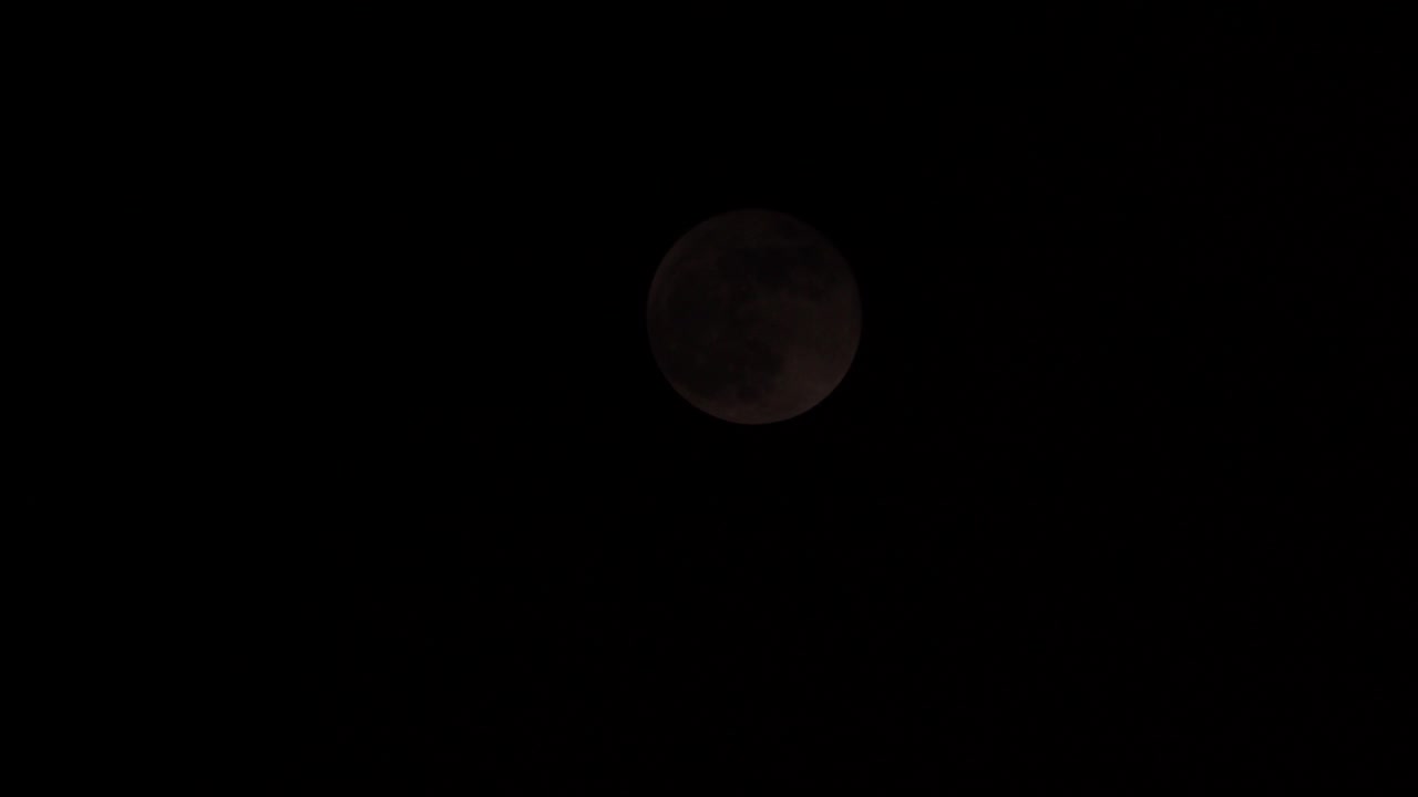 Black Clouds Passing In Front Of The Moon In The Dark Sky