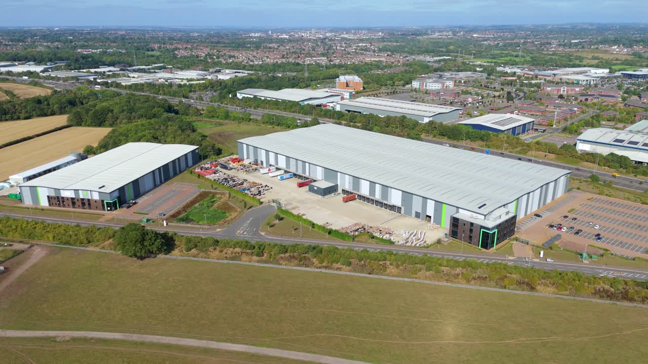 Sunset aerial drone footage of distribution centres and factories near M1 motorway with heavy road traffic and golden light Leicester England UK