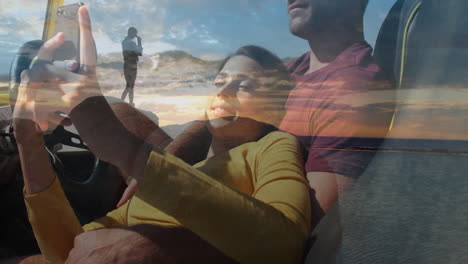 couple relaxing in car with sunset and beach overlay animation
