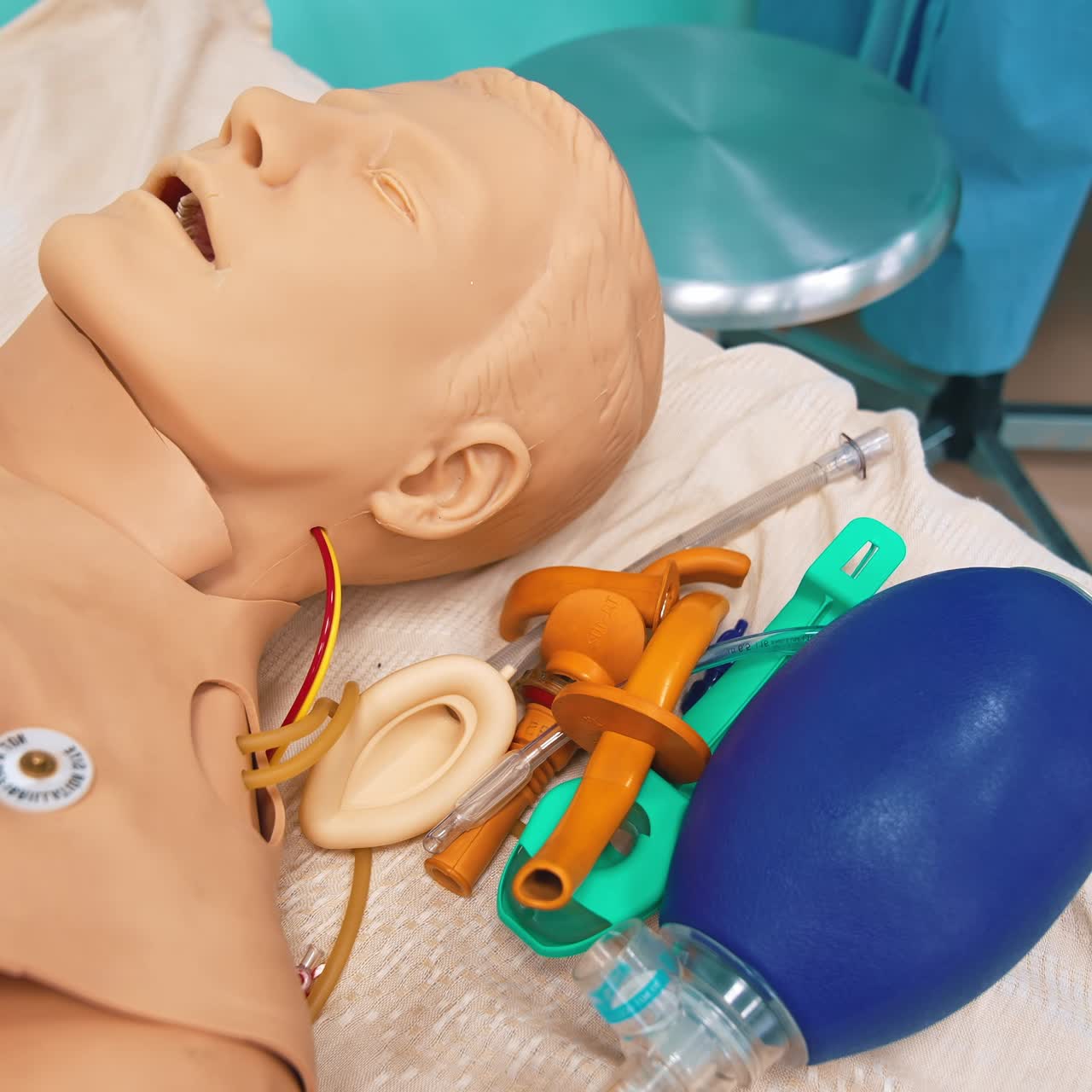 Plastic model of a man in hospital room. Male dummy with special equipment for teaching treatment. Mannequin to practice for university students. Close-up