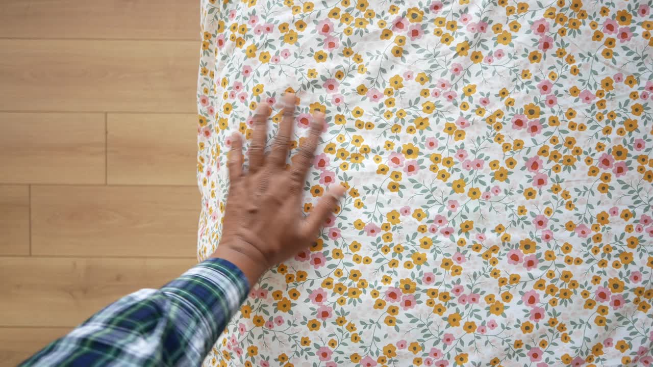 primer plano de una mano tocando una tela floral