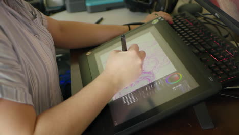 a caucasian woman's hand draws a digital illustration on a tablet in slow motion