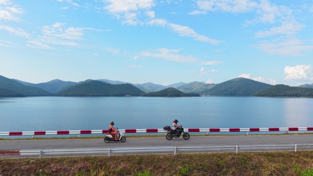 Motorcyclists enjoying a scenic lake and mountain view
