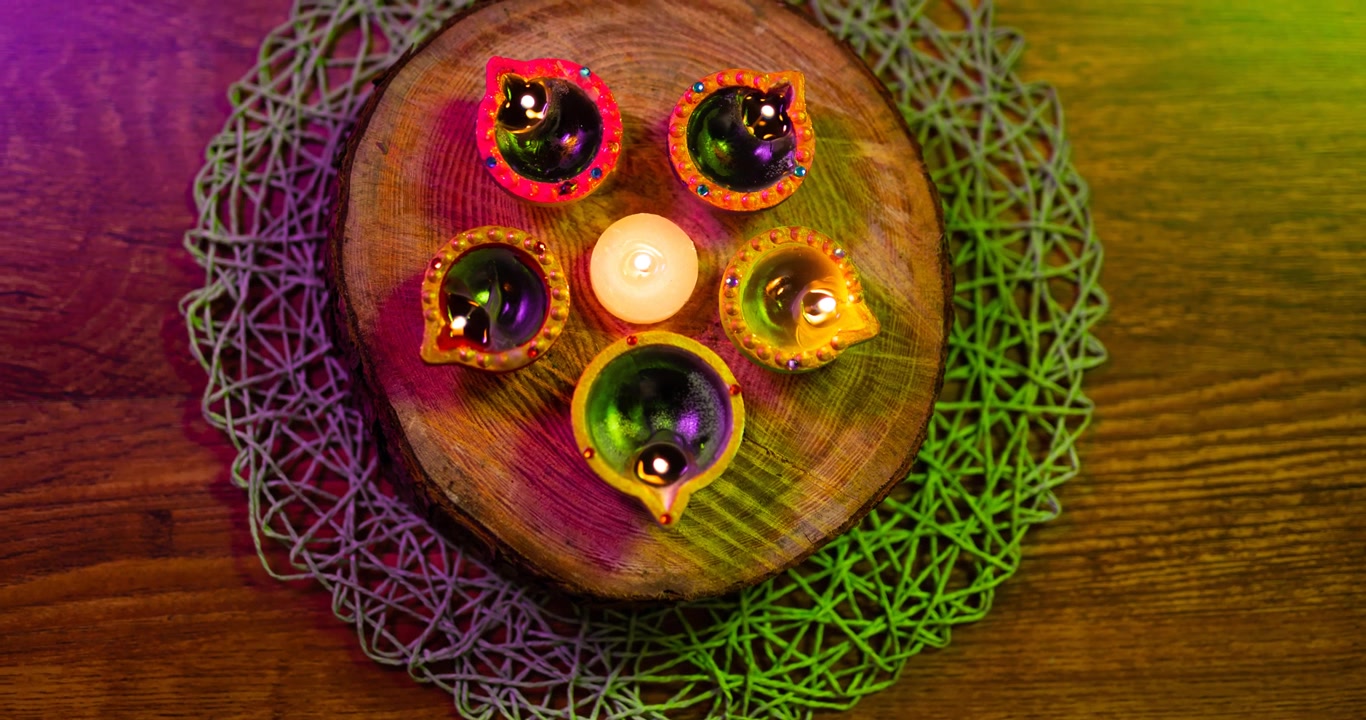 Video di candele Diwali accese e luminose disposte in cerchio su una superficie di legno.