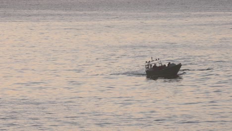 silhouette of fisher boat on sea at early