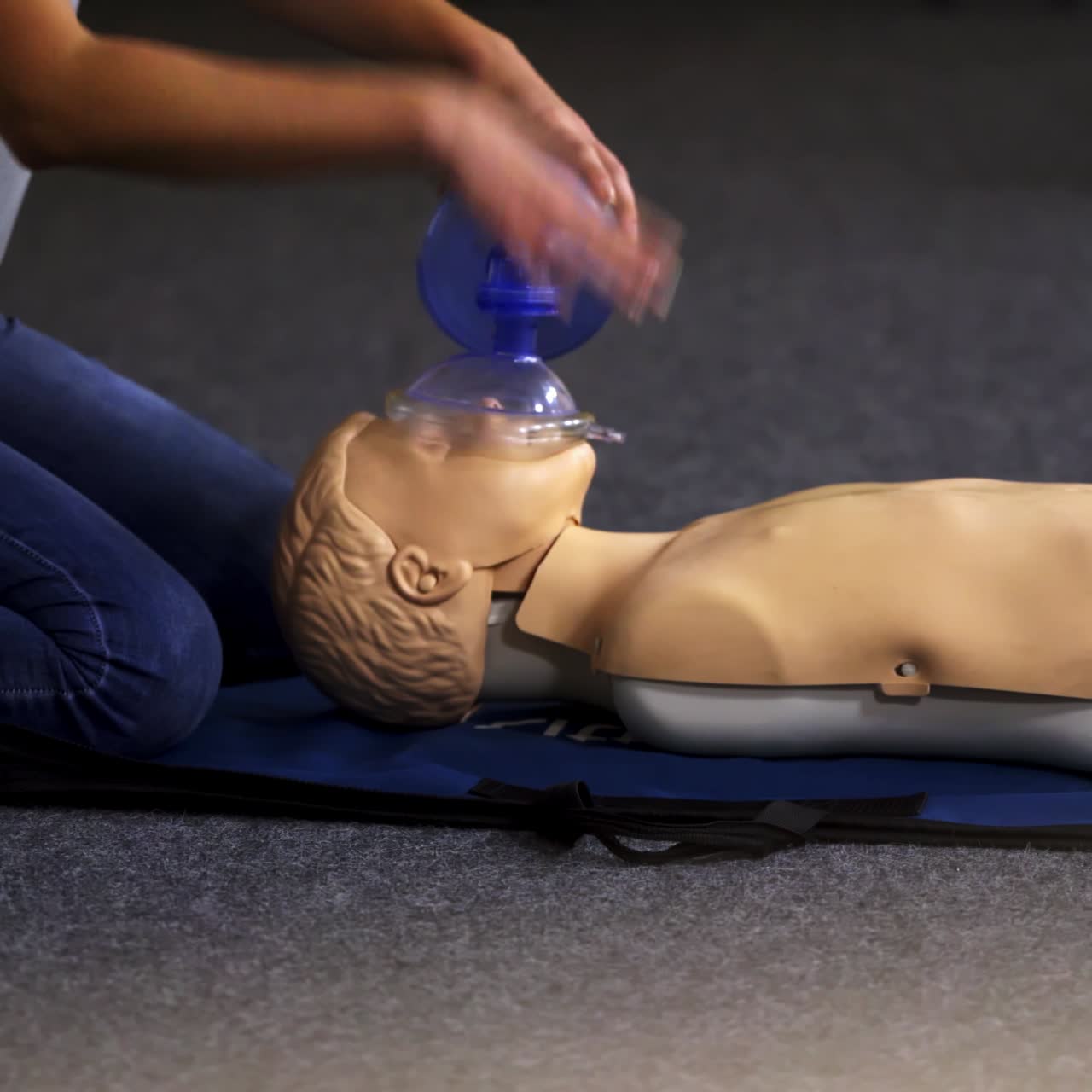 Medical doll lays on blue blanket ready for training. First medical help with oxigen masks video training