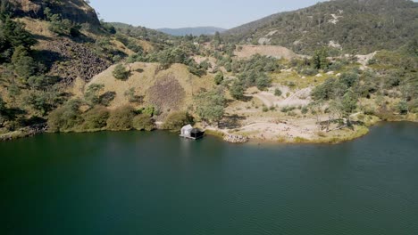 Antena-De-Sauna-Flotante-Del-Lago-Derby-En-Un-Día-De-Verano-Con-Turistas-Nadando-En-Derby,-Tasmania,-Australia