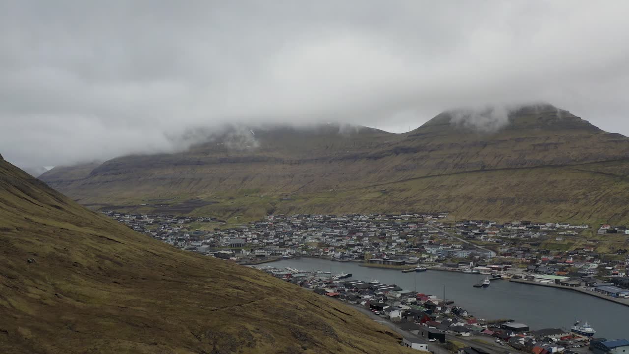 Ascending aerial shot Klaksvik town on Bor&eth;oy surrounded by hills, Faroe islands