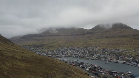 disparo aéreo ascendente de la ciudad de klaksvik en borðoy rodeada de colinas, islas feroe