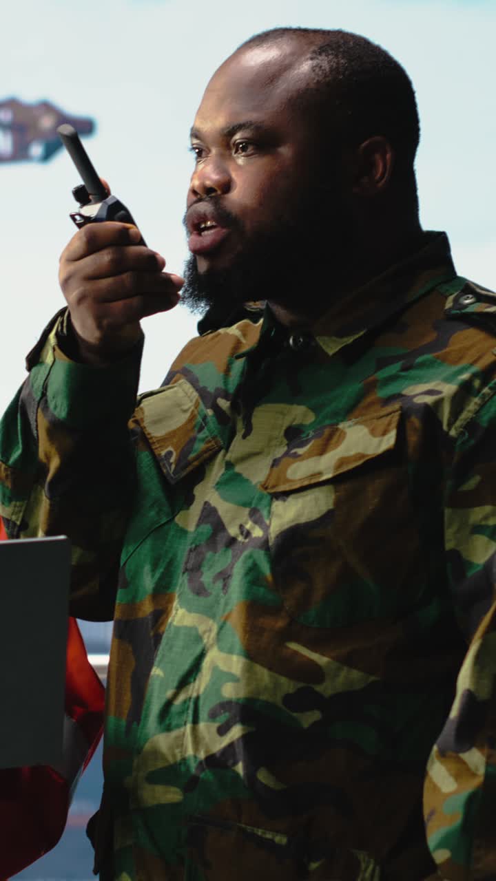 Vertical video Soldier working on offshore platform issuing command over radio transmission