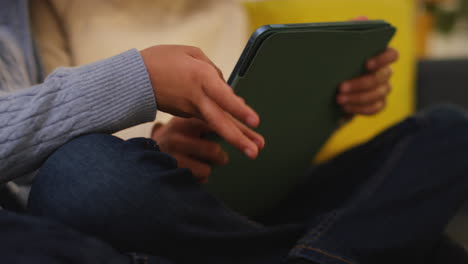dos niños pequeños sentados en el sofá en casa jugando juegos o transmitiendo a una tableta digital 4