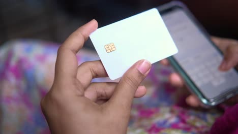 woman holding credit card and smartphone for mobile payment