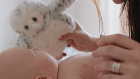 Madre-Feliz-Cuidando-Al-Bebé-En-Casa-Mamá-Amorosa-Cuidando-Al-Niño-Calmando-Suavemente-A-Su-Hijo-Con-Un-Juguete-De-Conejito-Disfrutando-De-La-Maternidad