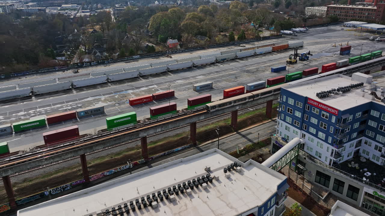 atlanta 공중 v779 설정 샷 낮은 수준의 조감도 무인 항공기가 hulsey 야드에서 달리는 기차를 따라가며 기울어져 도시 시내 풍경을 보여줍니다 - mavic 3 cine으로 촬영 - 2021년 12월