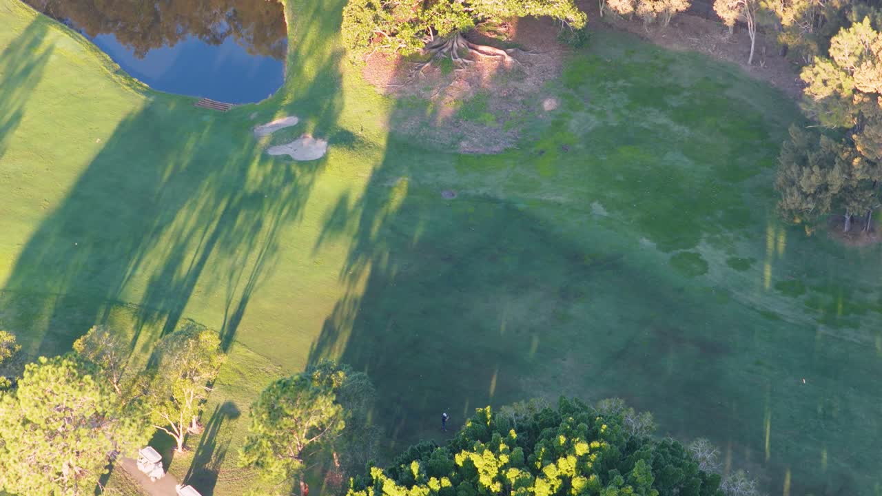Drone footage captures lush fairways and vibrant trees in warm, golden light at a Gold Coast golf course