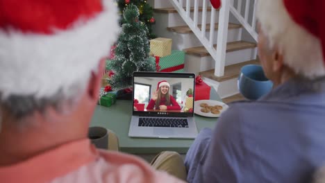 Happy-african-american-senior-couple-on-video-call-granddaughter-at-christmas