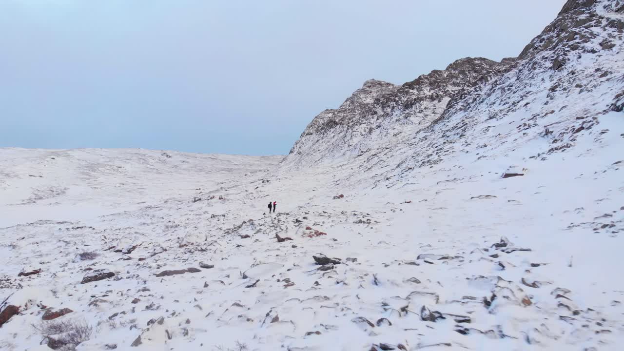 스웨덴 라플란드의 광대한 얼어붙은 흰색 풍경과 록키 산맥에서 길을 잃은 모험을 즐기는 등산객 - 공중 비행 샷