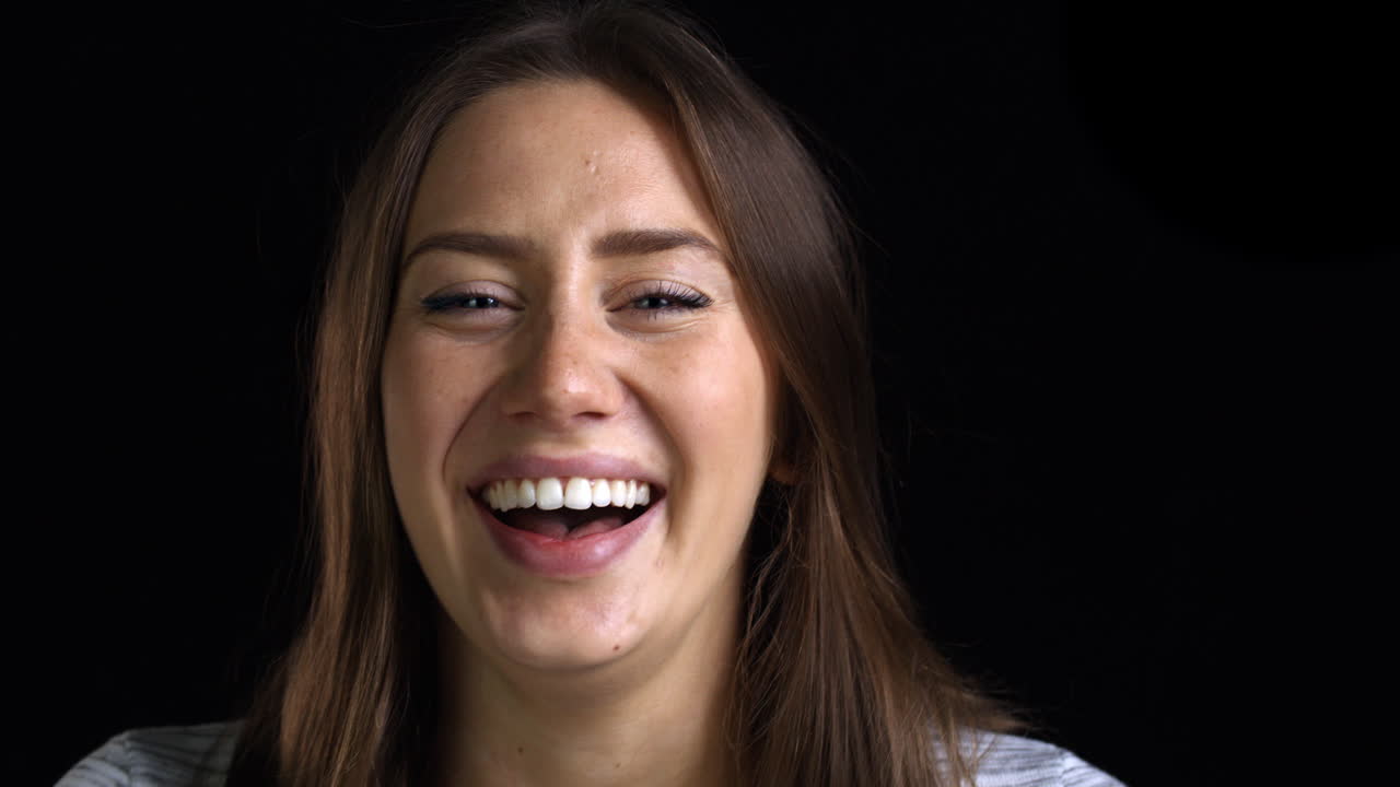 acercamiento de una joven atractiva riendo a la cámara