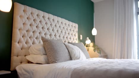 primer plano de un dormitorio soleado con pared verde, cámara lenta