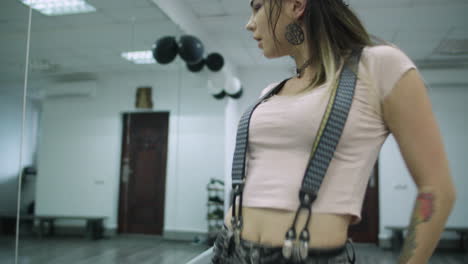 caucasian female dancer choreographer performing a freestyle dance against the mirror wall in a dance studio in slow motion