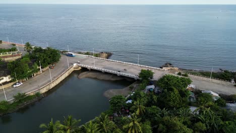 virac, catanduanes, philippines - vehicles cruising down the scenic coastal route of imelda boulevard - orbit drone shot