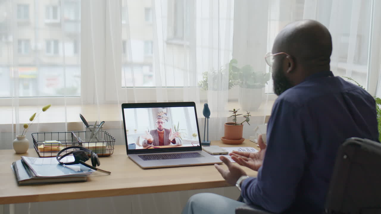 Black Man in Wheelchair Speaking with Colleague on Video Call