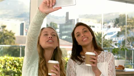 chicas bonitas tomando una selfie con tazas de café