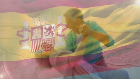 animación de la bandera de españa sobre una feliz pareja caucásica mayor bailando en la playa