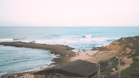 surfers walk over rocks to reach surf