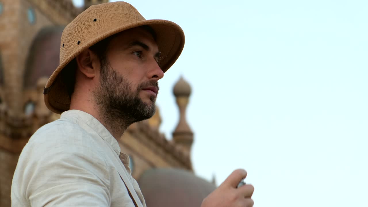 관광객은 무슬림 사원의 배경에 서 있습니다.