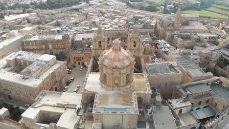 4k aerial drone footage, circling around st paul's cathedral in the stone fortified walled city of mdina of the northern region of malta