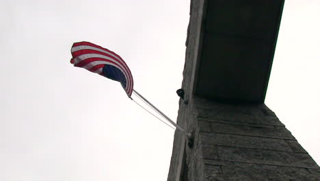 a cinematic pan under an american flag on a brick wall