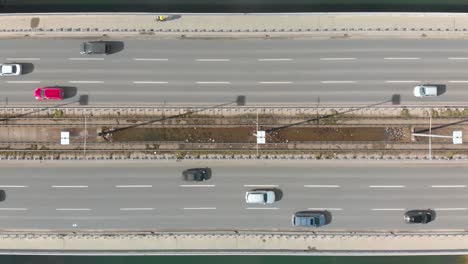 aerial drone flight top down view of high way busy city traffic jam and a cyclist on bicycle lane. car pooling natural power concept